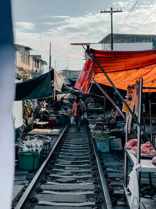 Besucher auf den Gleisen des Maeklong Railway Market